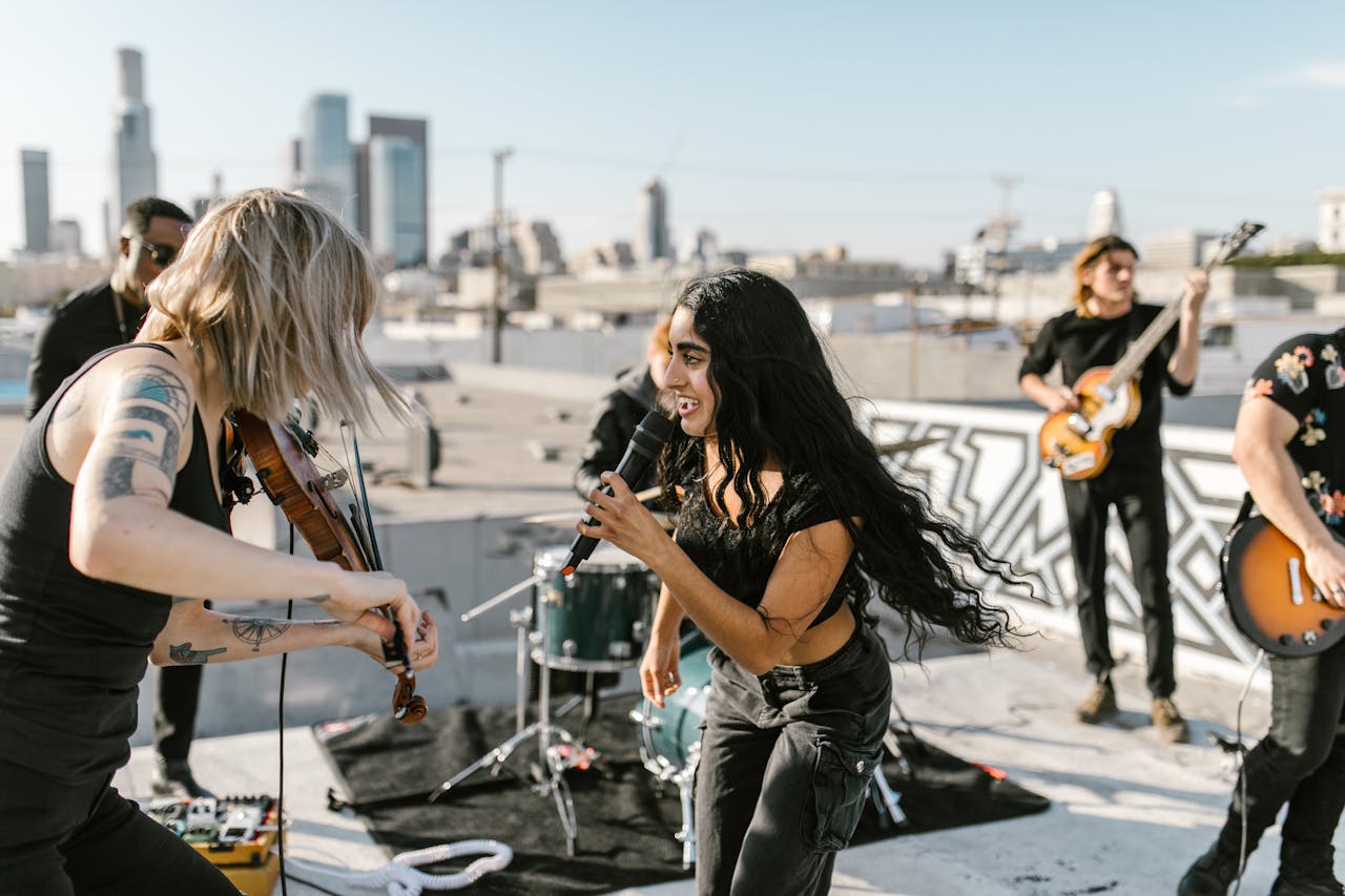 Indie band performing a lively rooftop concert with skyline in the background.