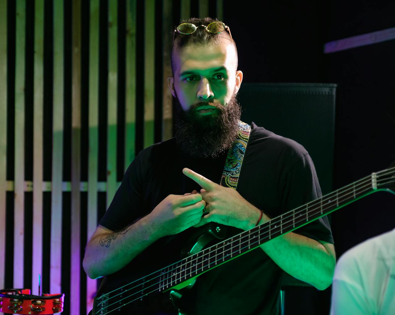 Portrait of a bearded bassist rehearsing in a music studio.